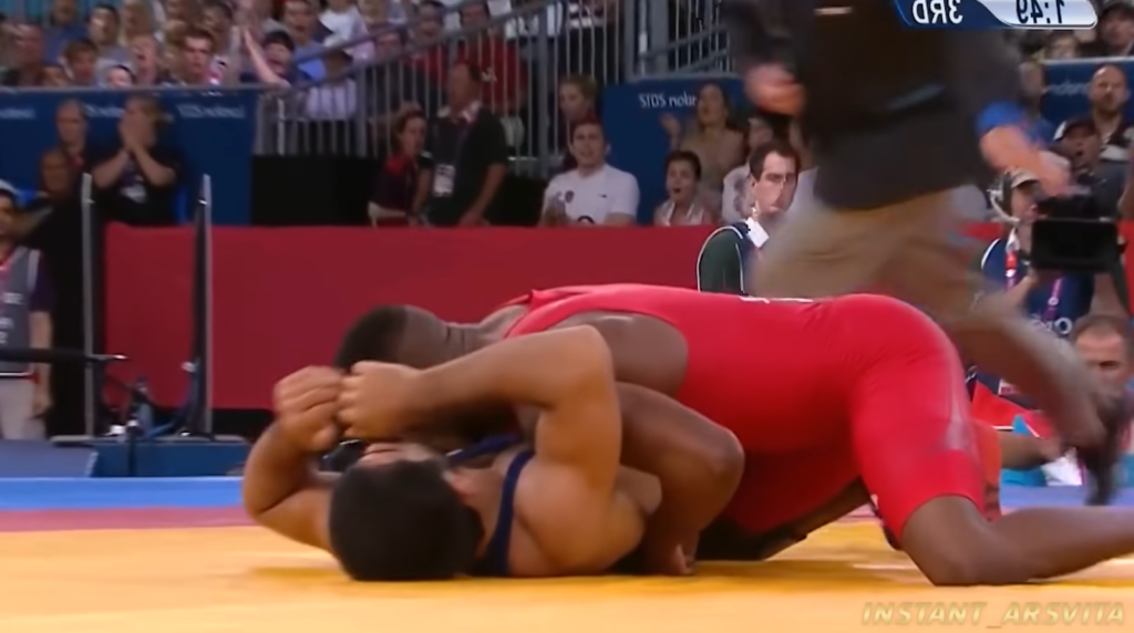 two opponents fighting during wrestling, both lying on the floor