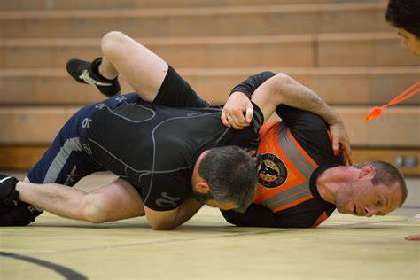 Two men wrestling on mats